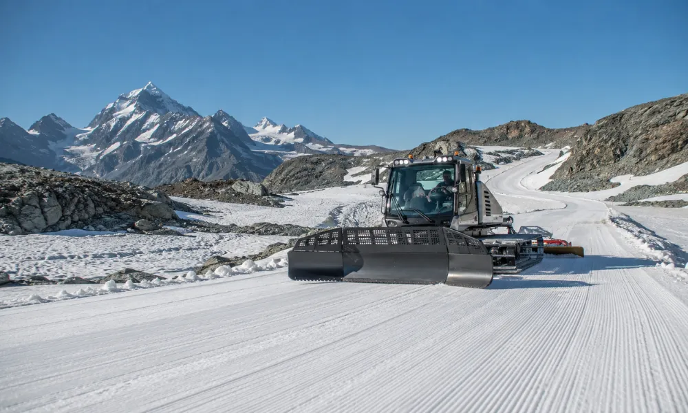 Summer ski resorts morning piste grooming on the glacier