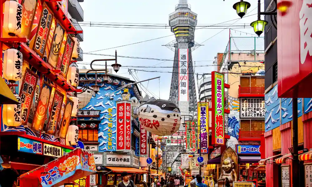 Two weeks in Japan guide with colourful Osaka street, food signs and Tsutenkaku tower